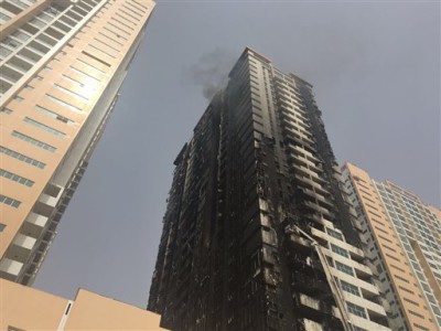 Smoke rises from a damaged residential tower after a fire erupted and burned up the side of several towers Monday night, in United Arab Emirates, Tuesday, March 29, 2016. Civil defense authorities put out the fire Tuesday morning at the Ajman One development in Ajman, a city that's home to many commuters who work in the Gulf commercial hub of Dubai, further to the south. (AP Photo/Fay Abuelgasim)