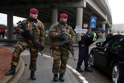 BRUSSELS, BELGIUM - MARCH 23: Belgian soldiers stand guard as police check vehicles outside of the closed Brussels Zaventem airport on March 23, 2016 in Brussels, Belgium. Belgium is observing three days of national mourning after 34 people were killed in a twin suicide blast at Zaventem Airport and a further bomb attack at Maelbeek Metro Station. Two brothers are thought to have carried out the airport attack and an international manhunt is underway for a third suspect. The attacks come just days after a key suspect in the Paris attacks, Salah Abdeslam, was captured in Brussels. (Photo by Adam Berry/Getty Images)