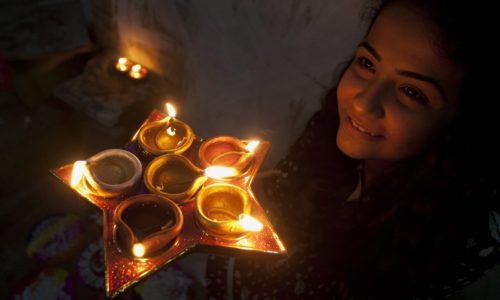 A girl from the Hindu community holds earthen oil lamps to celebrate the Diwali festival, in Karachi, Pakistan, Sunday, Oct. 30, 2016. Diwali, the festival of lights, is one of Hinduism's most important festivals dedicated to the worship of Lakshmi, the Hindu goddess of wealth. (AP Photo/Shakil Adil)